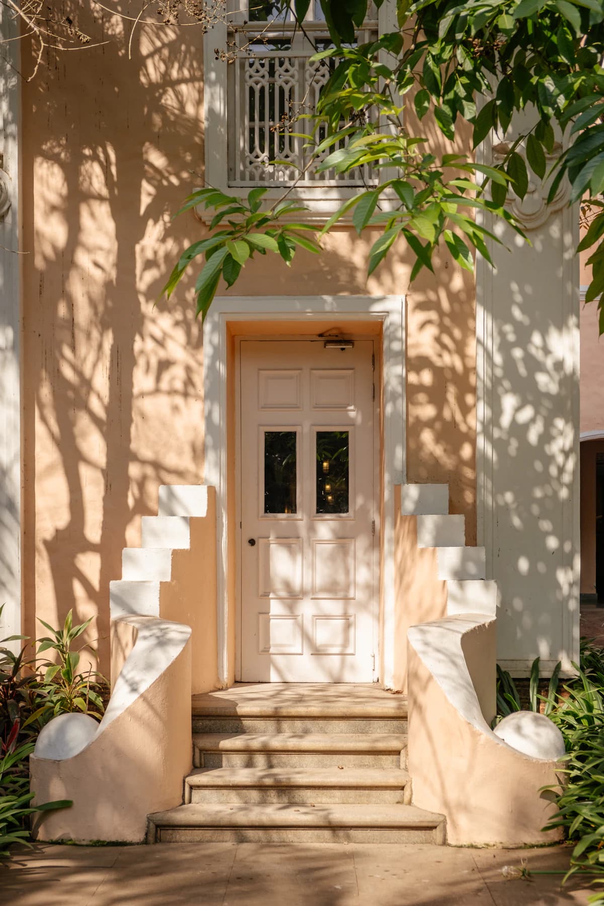 Sunlit residential entryway framed by greenery